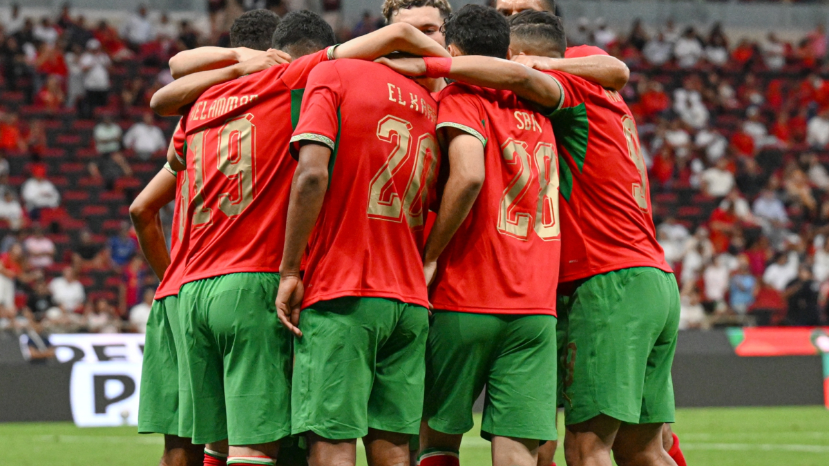Moroccan women's football team celebrating a goal on the pitch.
