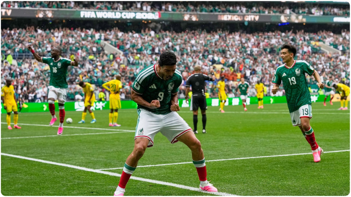 A dramatic shot of a Mexican national team player, Raúl Jiménez, celebrating a goal during a night match at the World Cup, with stadium lights illuminating the scene.