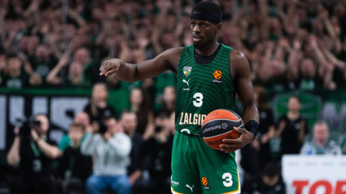 A basketball player in motion, with dramatic lighting, on a basketball court.