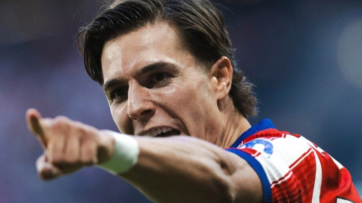 Giocatori del Manchester United e dell'Atlético Madrid in campo durante un match, con un attaccante che cerca di segnare e un portiere che blocca un tiro