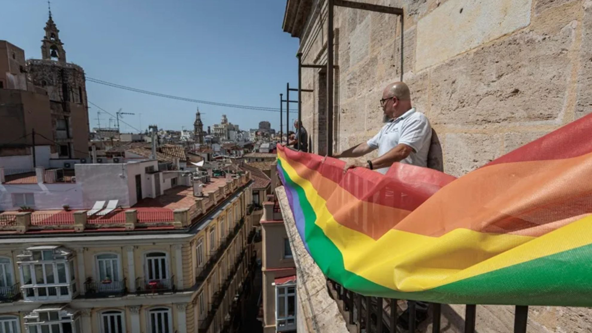 Un balcone con bandiere, un edificio urbano, un cartello con multa