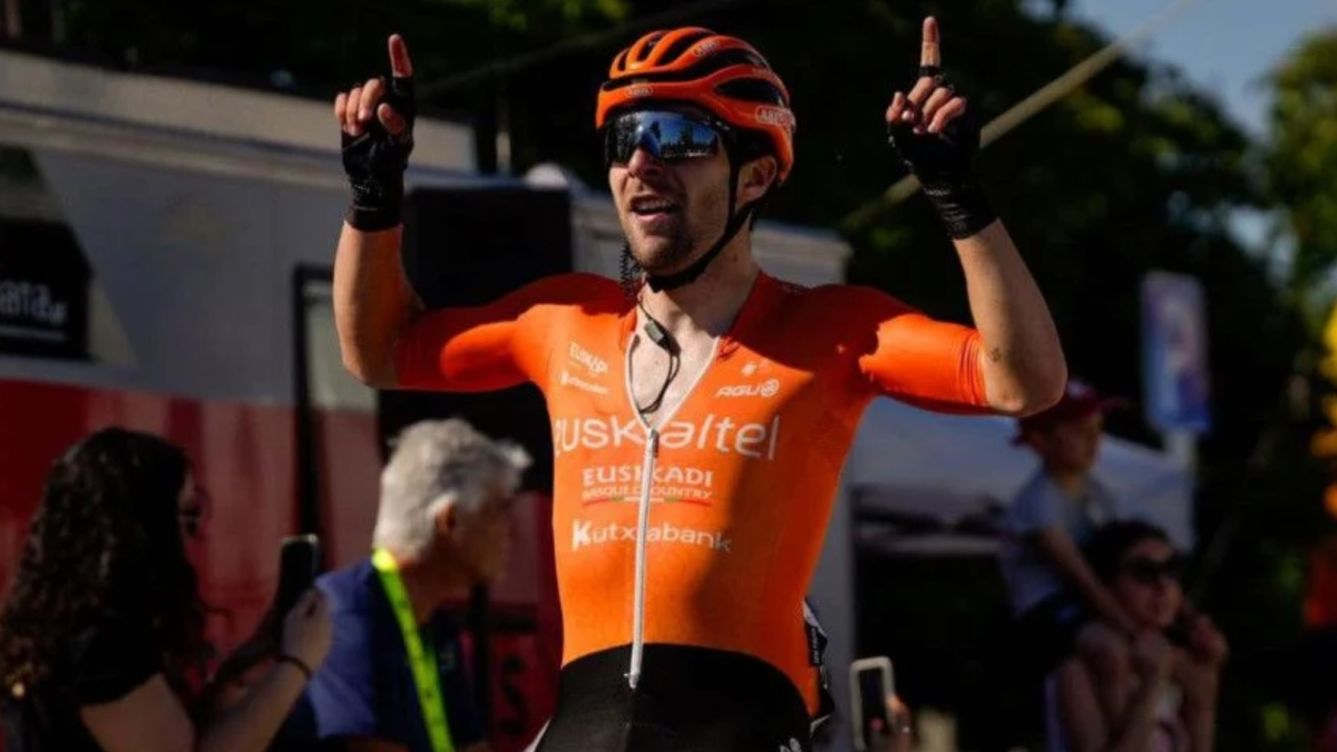Ciclista spagnolo in abiti morati, in una gara di ciclismo, con un team di supporto