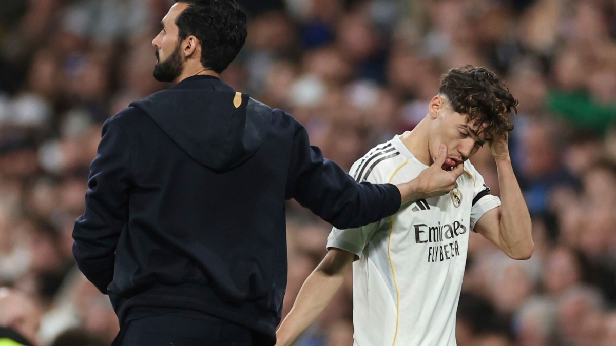 Un giocatore del Real Madrid osserva il campo durante un allenamento, mentre un dirigente del Fulham osserva da lato
