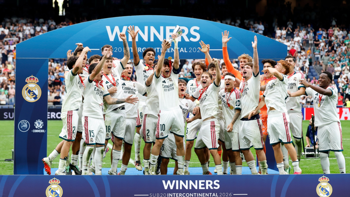 Real Madrid U19 players celebrating with the U-20 Intercontinental Cup trophy on the Santiago Bernabéu pitch.