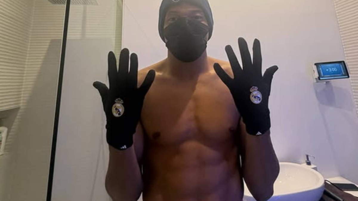 Kylian Mbappé training with Real Madrid, wearing the white kit and showing a serious expression.