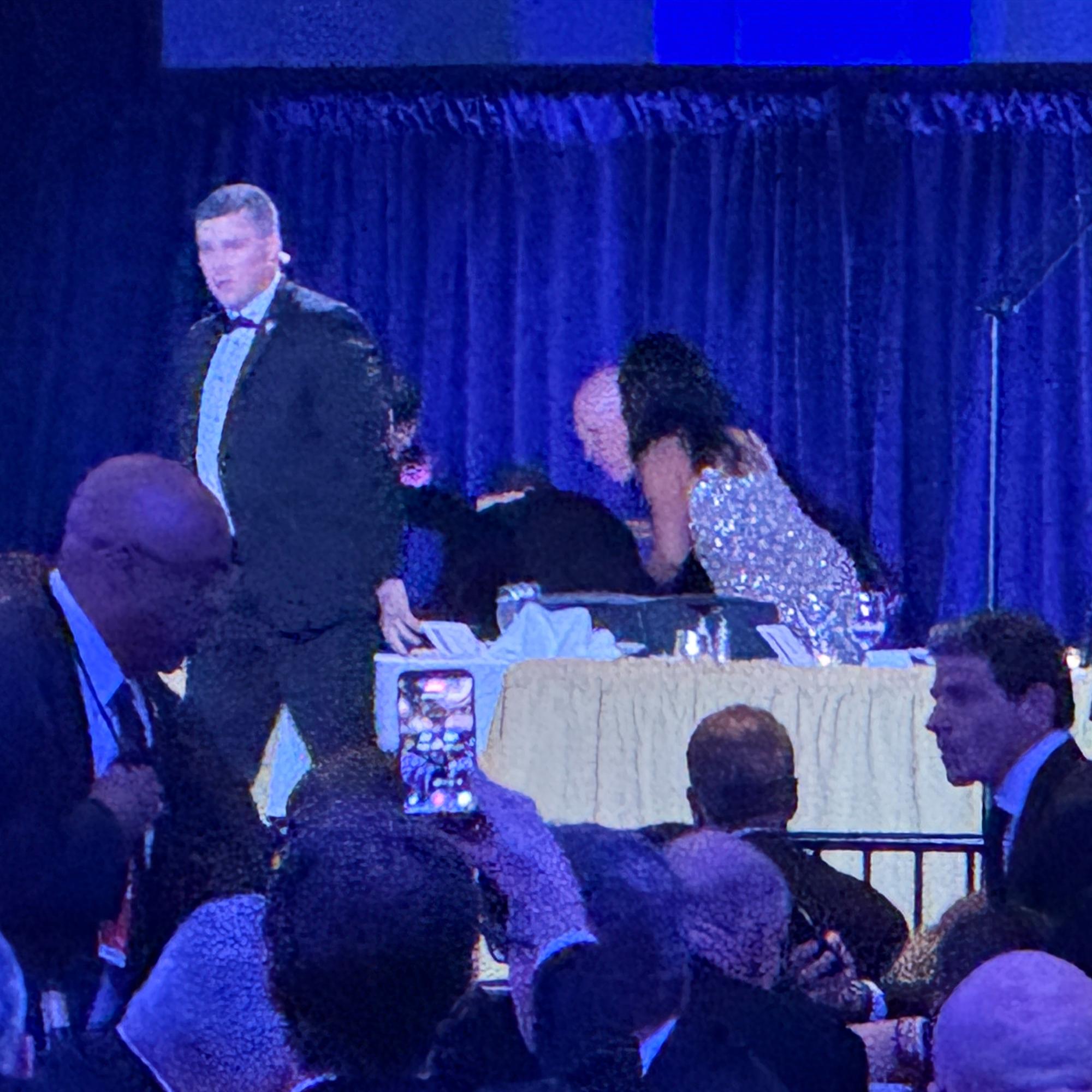 U.S. Secret Service agents surround President Donald Trump as he is taken from the stage after a shooting incident outside the ballroom during the White House Correspondents Dinner, Saturday, April 25, 2026, in Washington. (AP Photo/Mark Schiefelbein)
