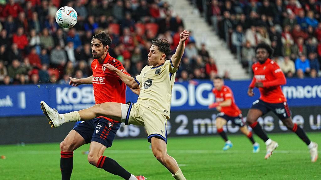 Osasuna's Alejandro Catena, left, and Barcelona's Fermín López battle for the ball during a Spanish La Liga soccer match between Osasuna and Barcelona in Pamplona, Spain, Saturday, May 2, 2026. (AP Photo/Miguel Oses)