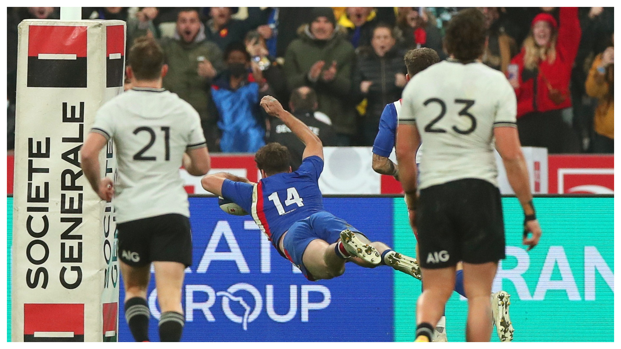 Damian Penaud ensaya ante la mirada de dos jugadores de los All Blacks.