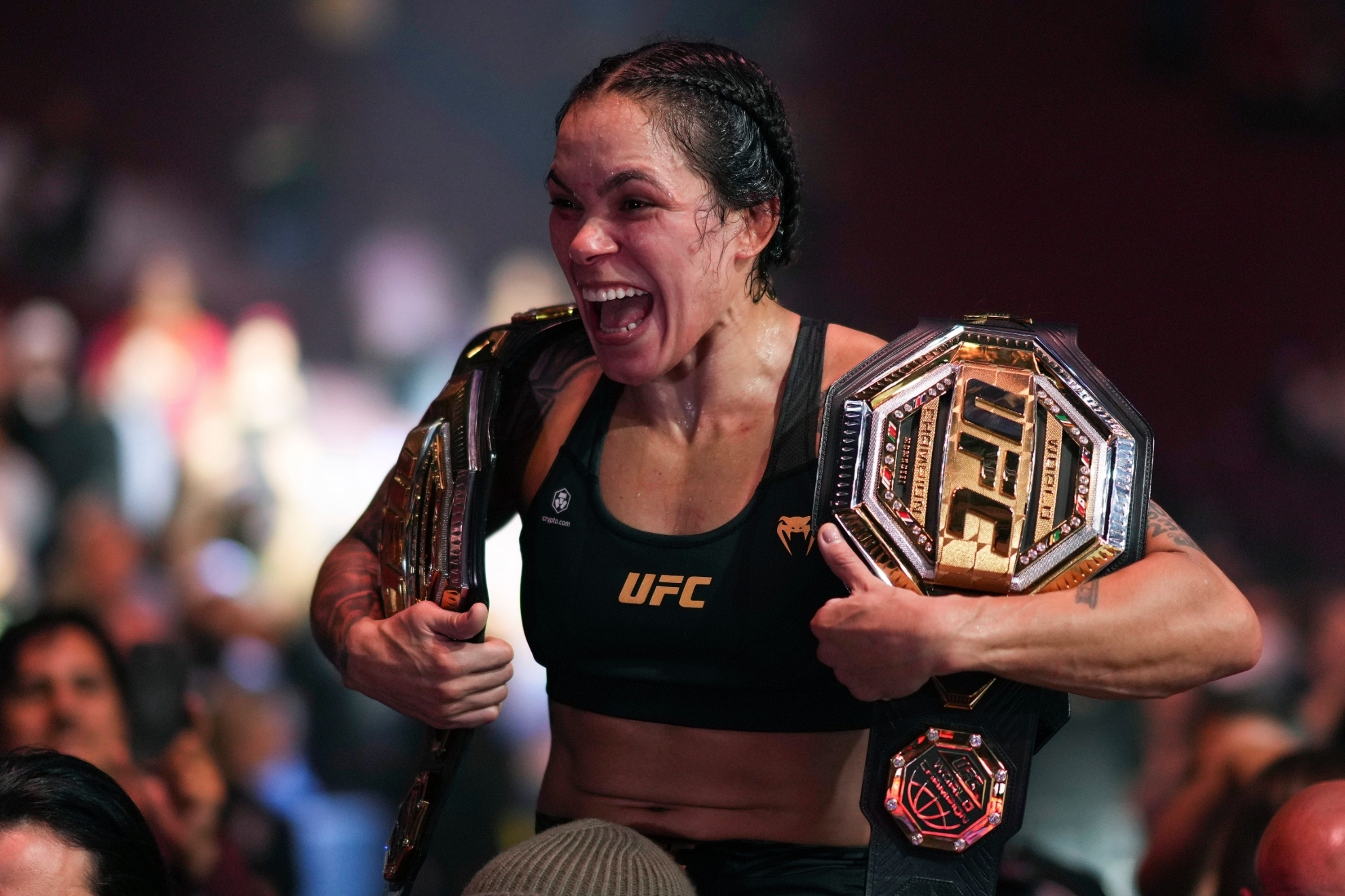 Amanda Nunes con sus dos cinturones de campeona.