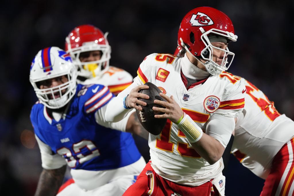 Mahomes, seguido por varios defensores.