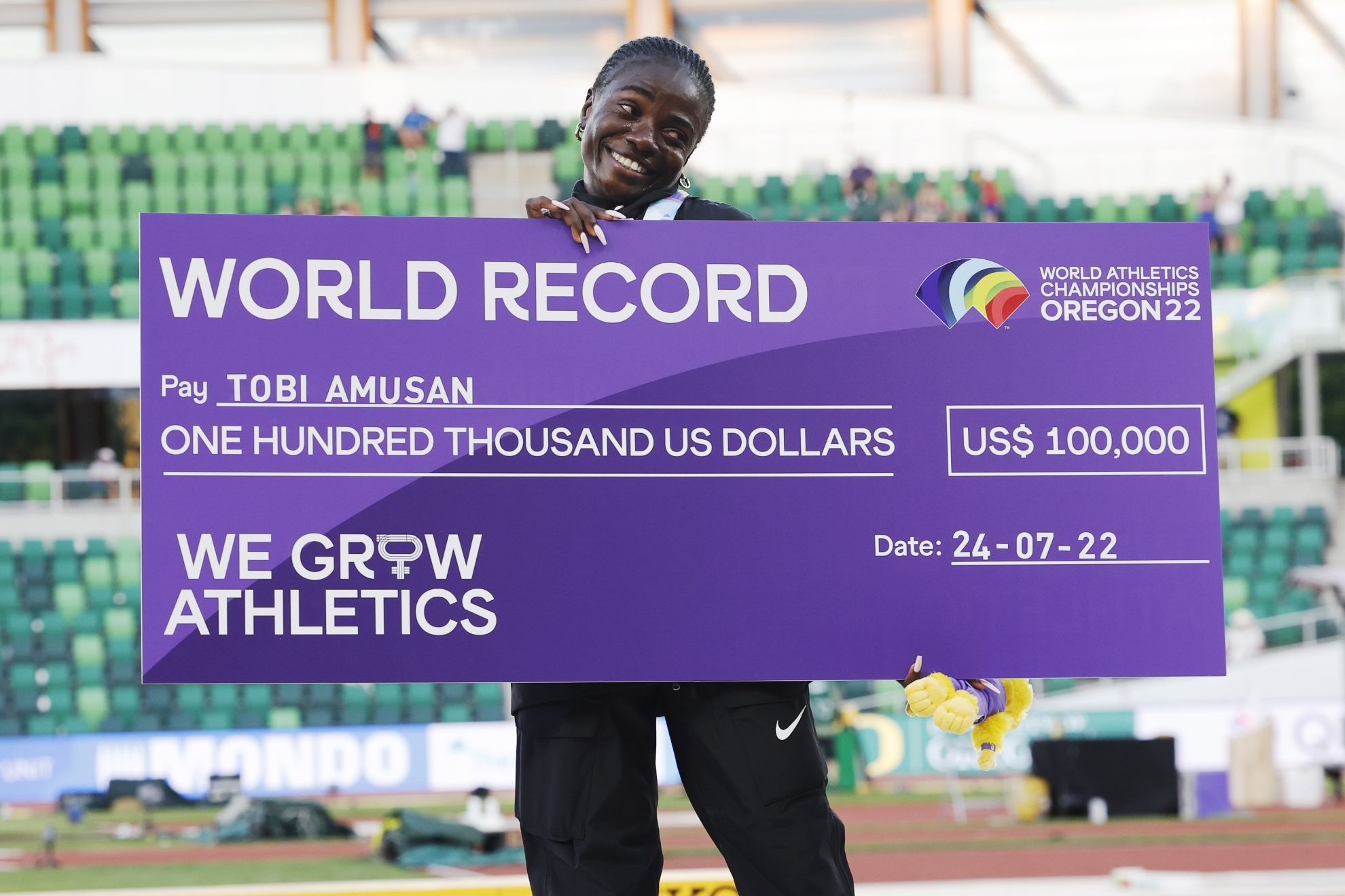 Tobi Amusan celebra con el 'cheque' de 100.000 dólares por batir el récord del mundo de los 100 vallas en el Mundial de Eugene 2022.