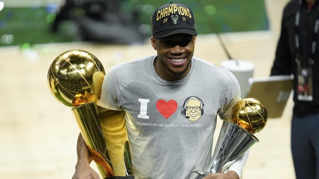 Giannis Antetokounmpo, con los trofeos de campeón de la NBA y de MVP.