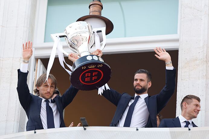 Modric, Nacho enseñan la Copa desde el balcón de la Comunidad de Madrid.