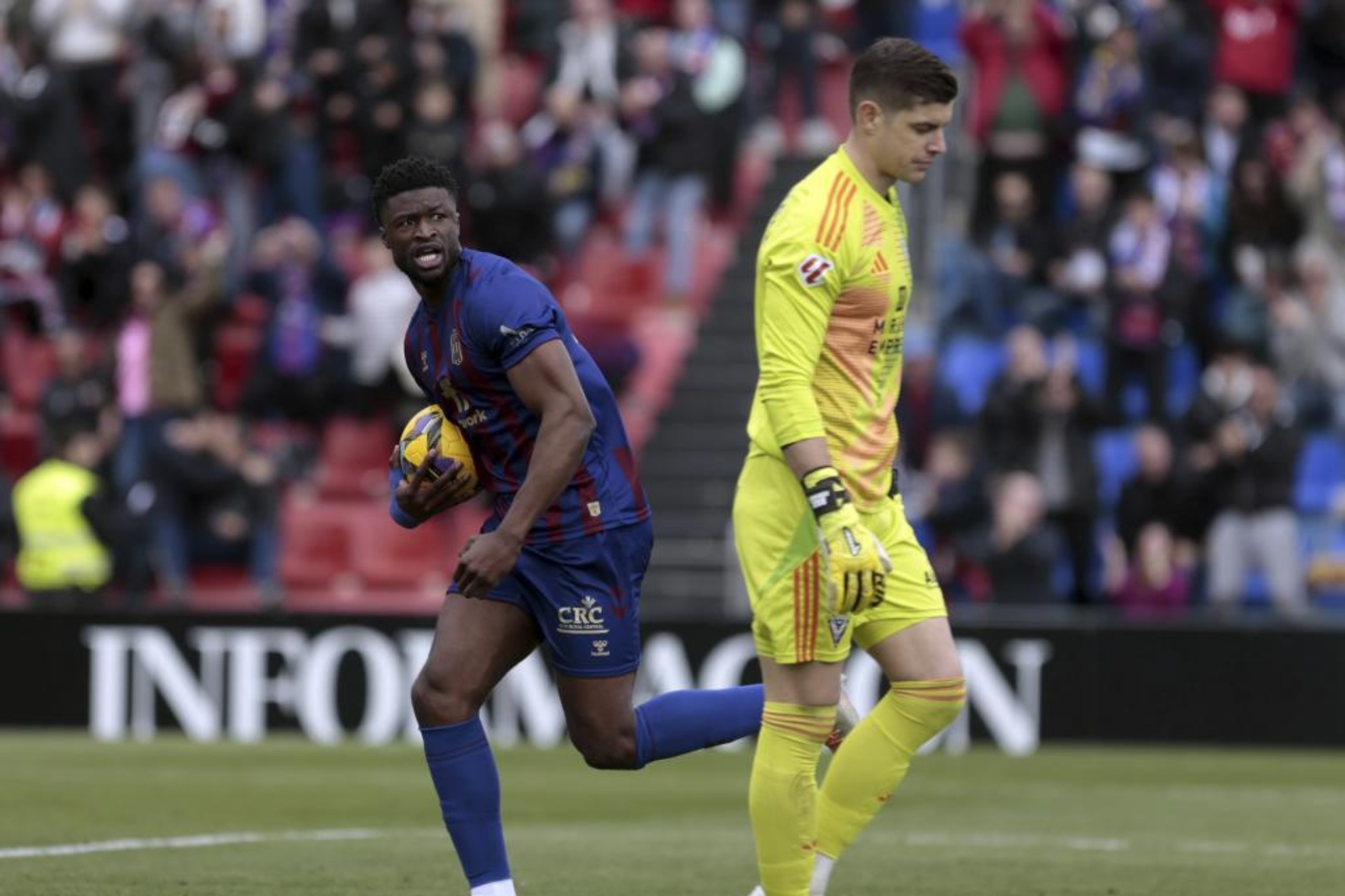Gassama, asistente en el 2-1 del Eldense, corre con el balón ante la decepción de Fernández.