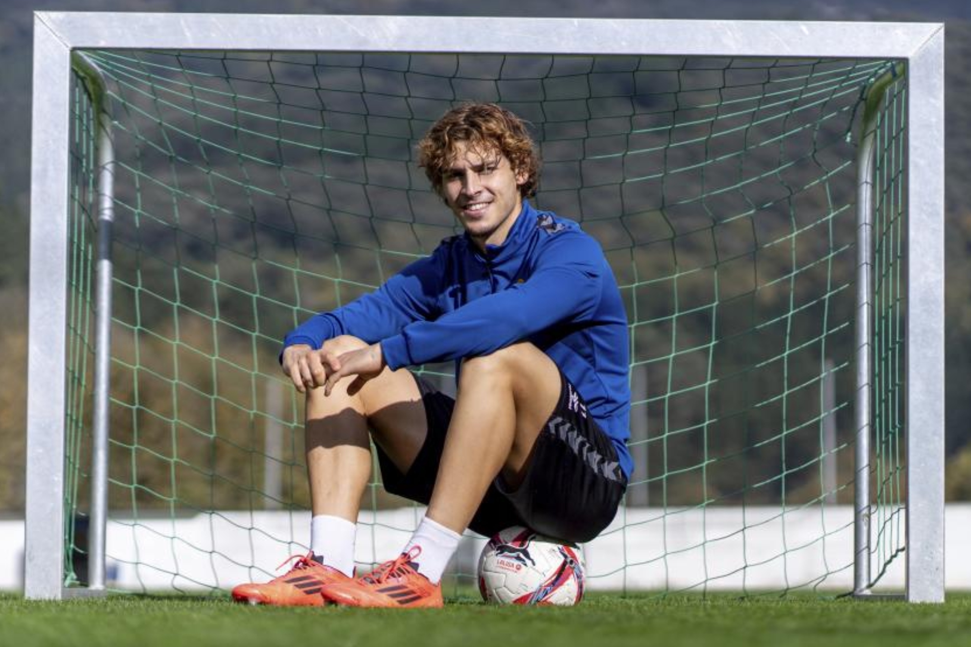Jorge Pascual posa sentado en un balón y delante de una portería.