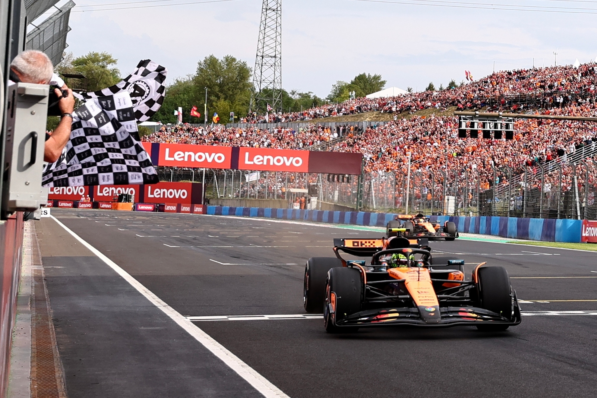 Lando Norris cruzando la línea de meta en la primera posición.