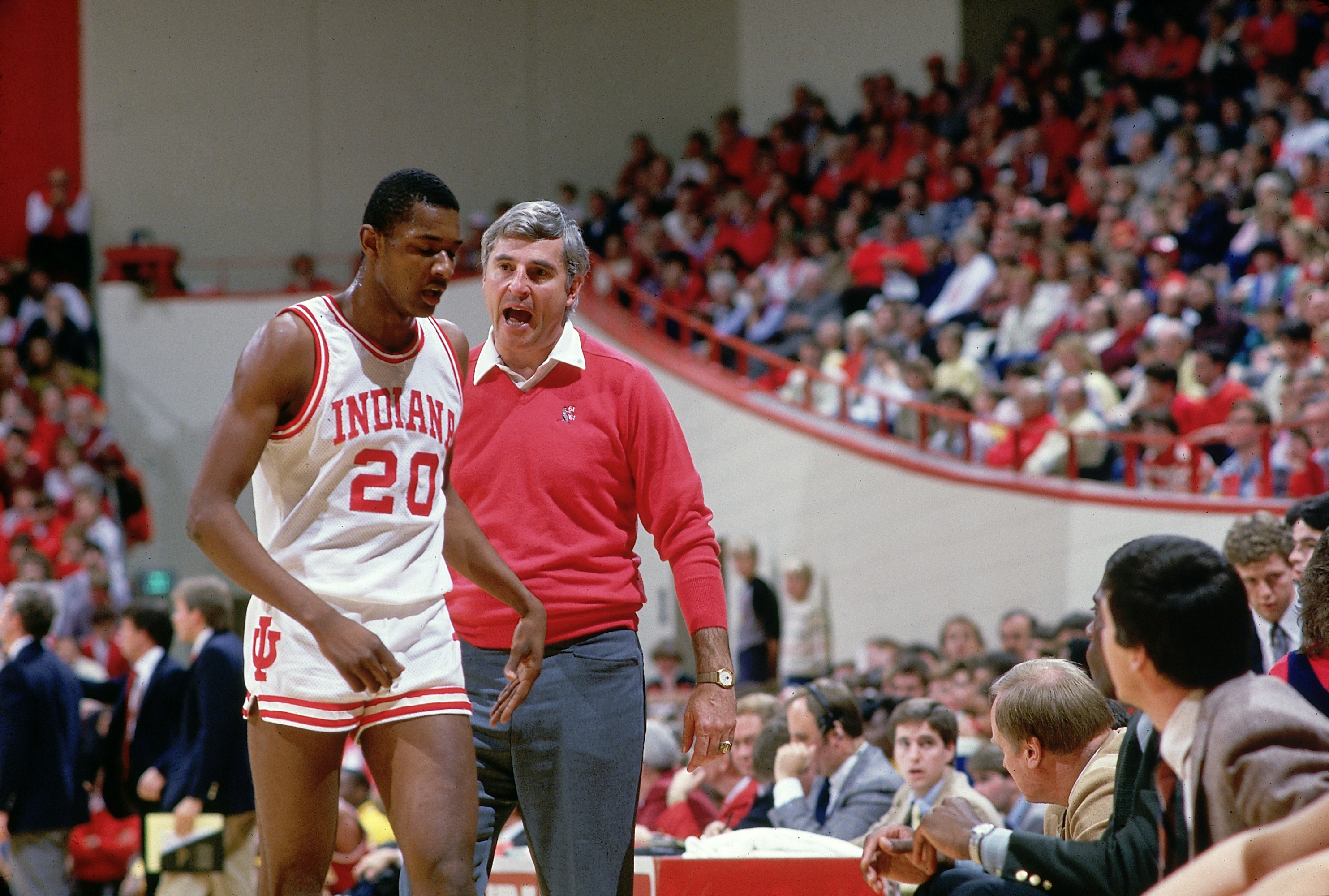 Bobby Knight, de rojo, abronca a un jugador de Indiana al llevarle al banquillo.