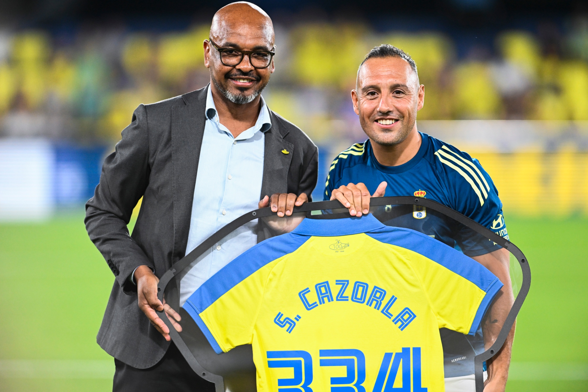Marcos Senna entrega un obsequio a Cazorla. EFE
