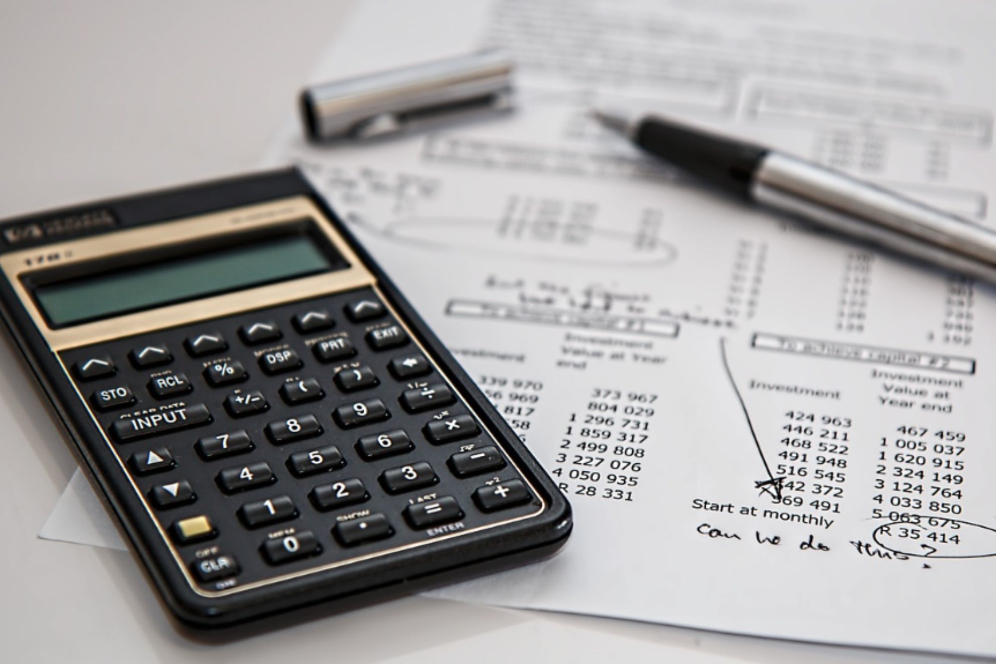 Imagen de una nómina y una calculadora junto a un bolígrafo.