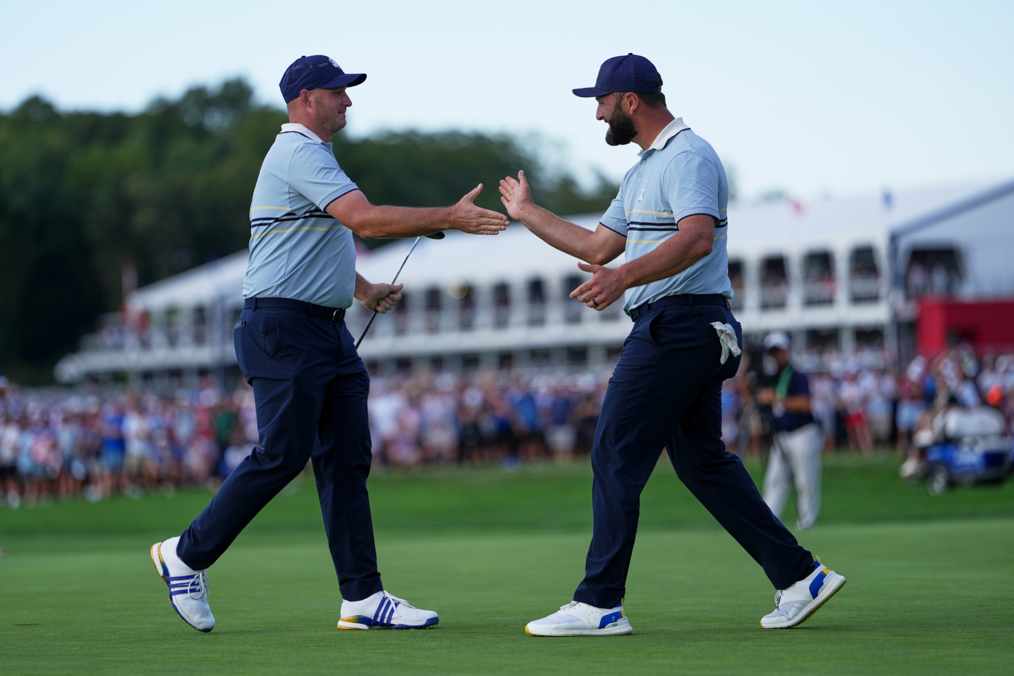Straka y Rahm chocan la mano durante el partido de fourballs.