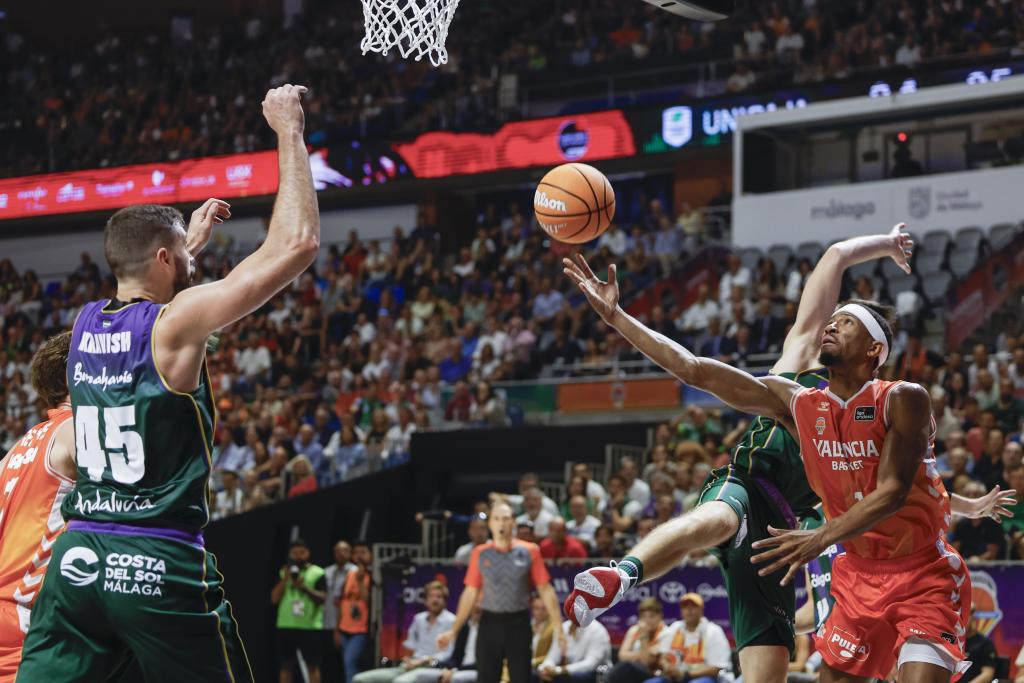 El base estadounidense del Valencia Kameron Taylor (d) lanza a canasta.