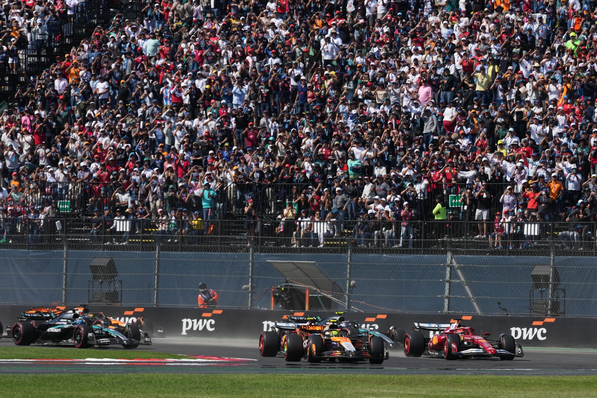 Lando Norris lidera al resto de pilotos en la primera curva del GP de México.