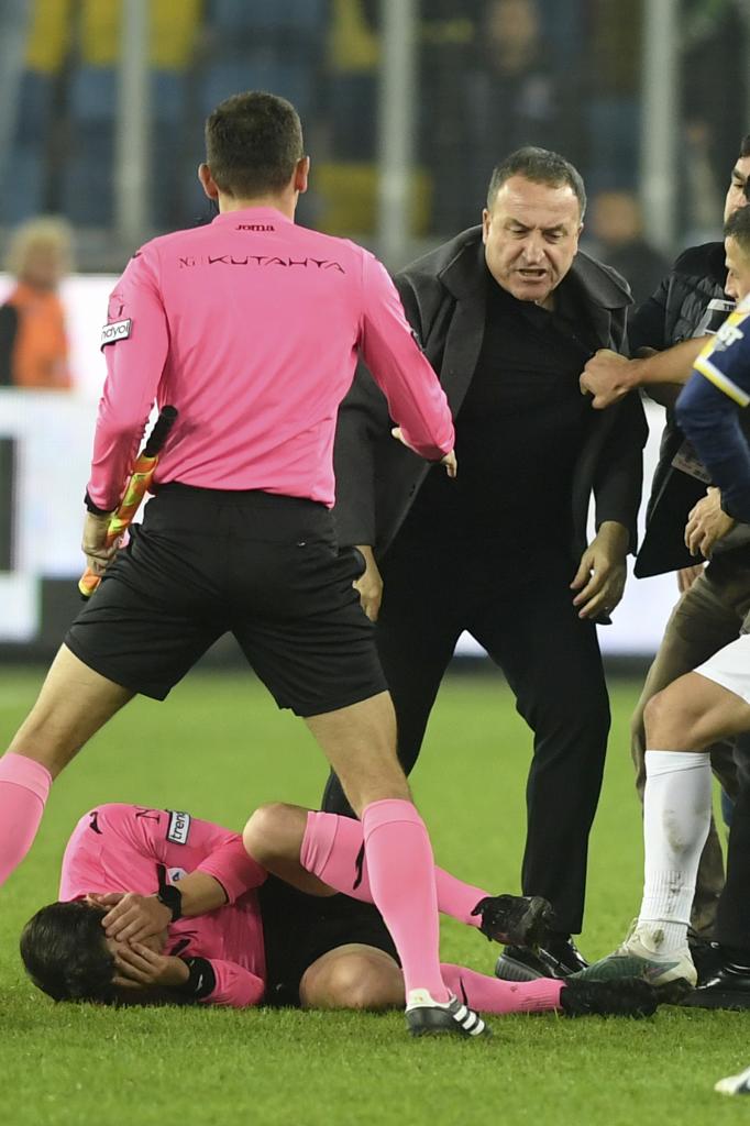 El árbitro Halil Umut Meler se toca el rostro mientras yace tendido en el césped tras ser golpeado por el presidente del MKE Ankaragucu
