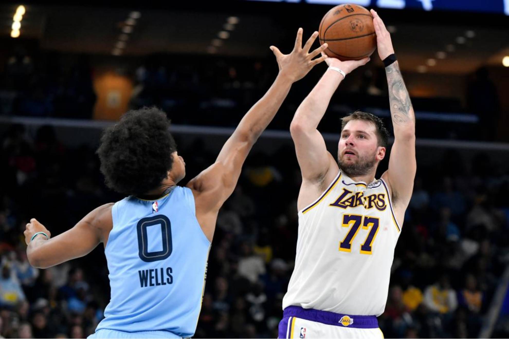 Luka Doncic lanza a canasta sin que Jaylen Wells, de los Grizzlies, logre puntear su tiro.