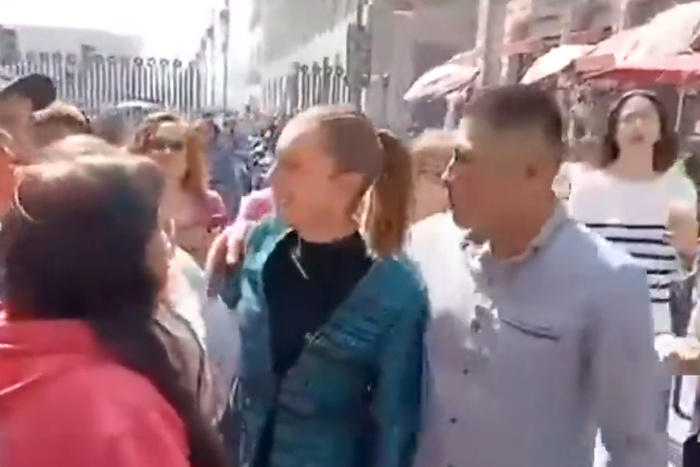 Sheinbaum abrazada por un individuo en plena calle.