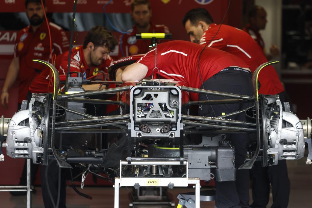 Integrantes de la escudería Ferrari trabajan en el vehículo del británico Lewis Hamilton durante el primer día de actividades previo al Gran Premio de Fórmula 1 de este jueves, en el circuito de Interlagos, en Sao Paulo (Brasil)