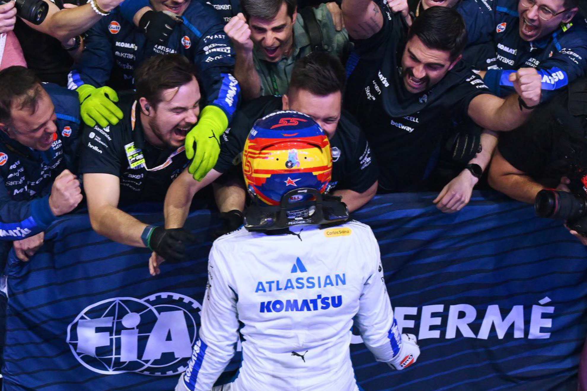 Sainz celebrando el podio en Qatar con sus mecánicos.