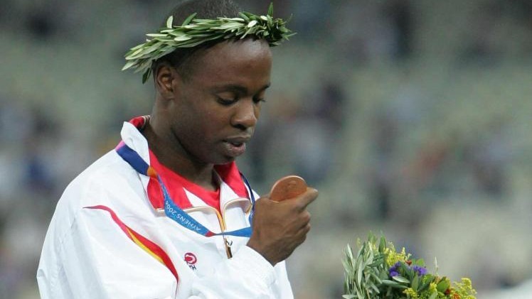 Joan Lino Martínez mira su medalla olímpica en el podio de Atenasl 2004