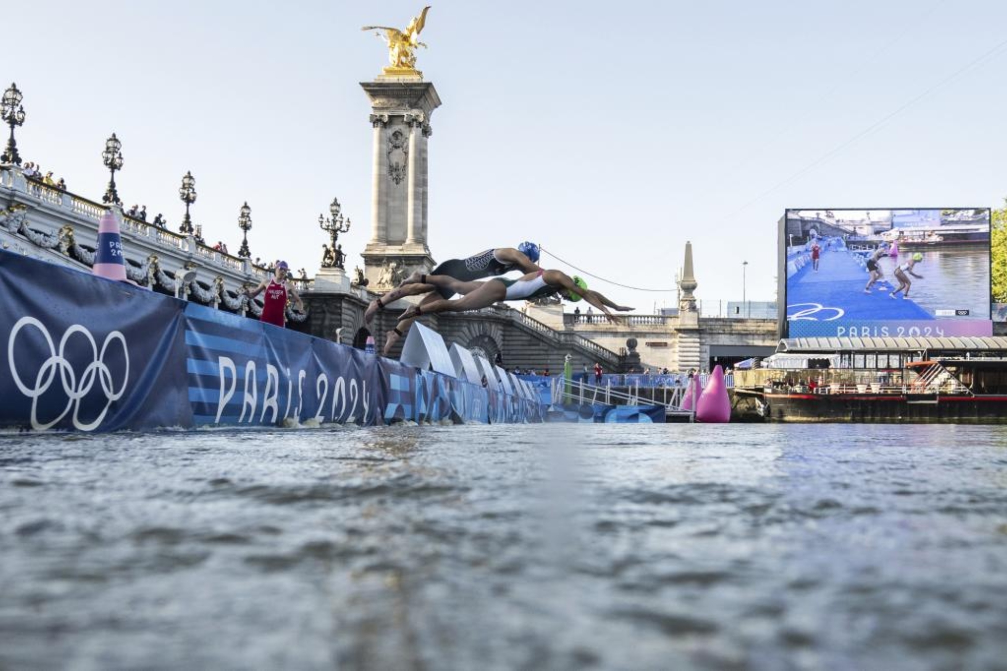 Dos triatletas se lanzan al agua desde el portón de Pont de Alexandre III