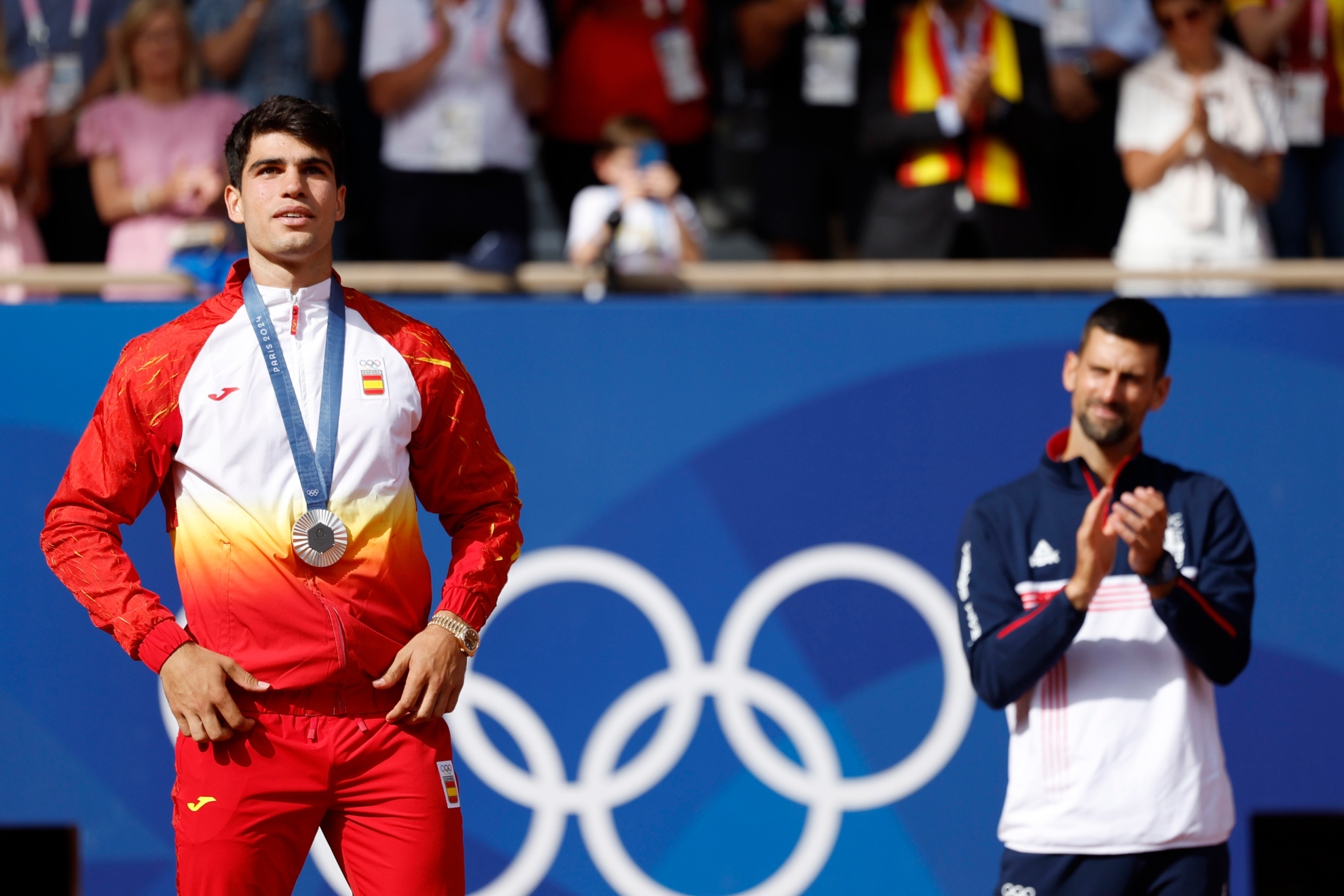 Djokovic apaludiendo a Alcaraz tras conseguir la medalla de plata.