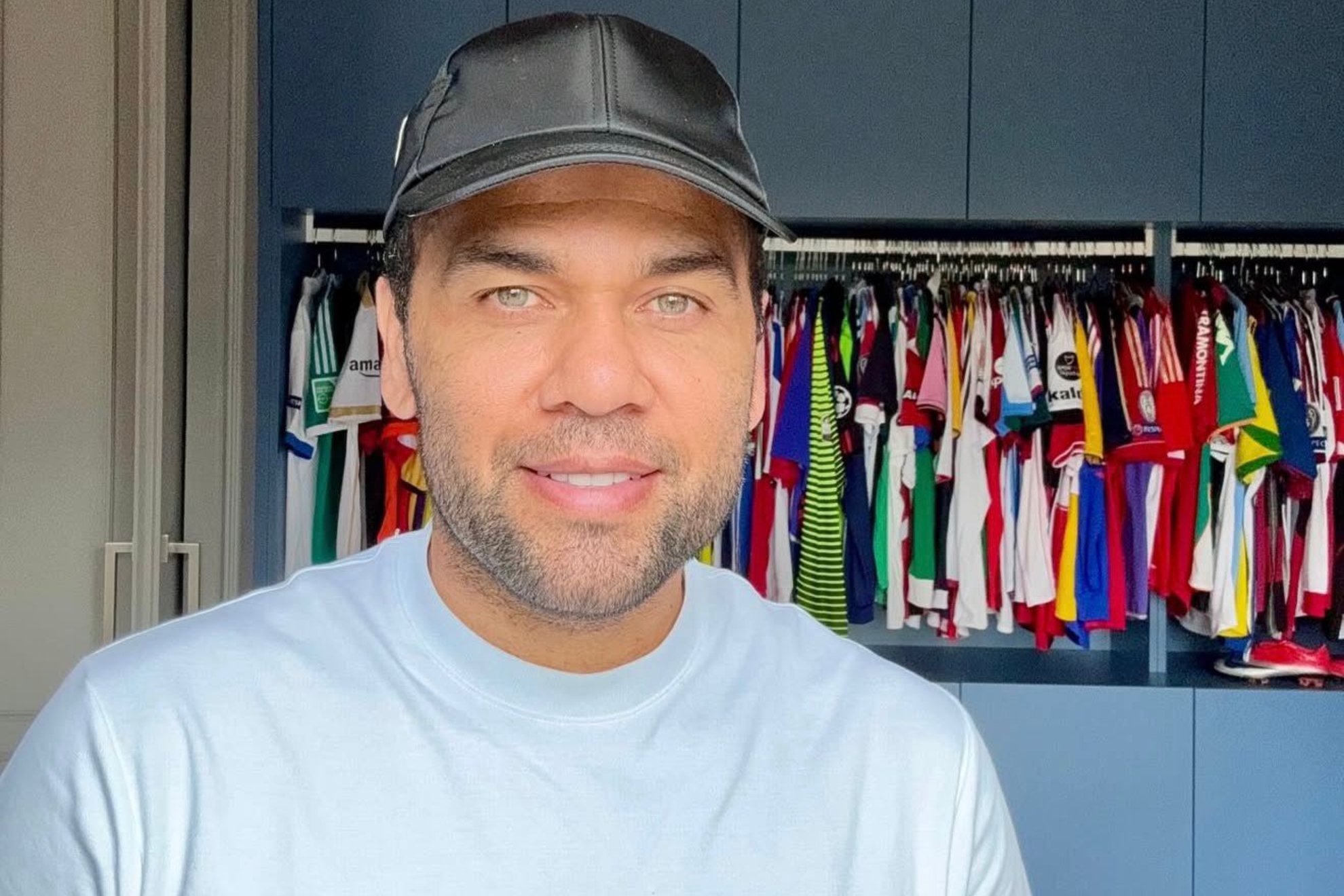 Dani Alves posa junto a su colección de camisetas.