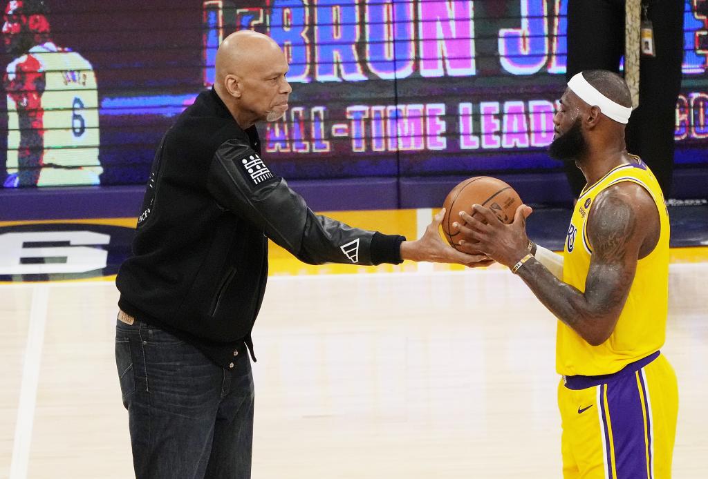 Kareem Abdul-Jabbar entrega a LeBron James el balón con el que se convirtió en el máximo anotador de la historia de la NBA.