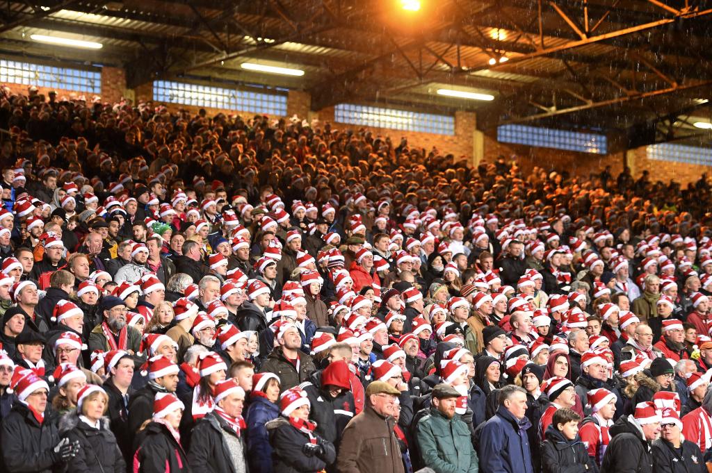 Aficionados ataviados con gorros de Santa Claus llenan la grada.