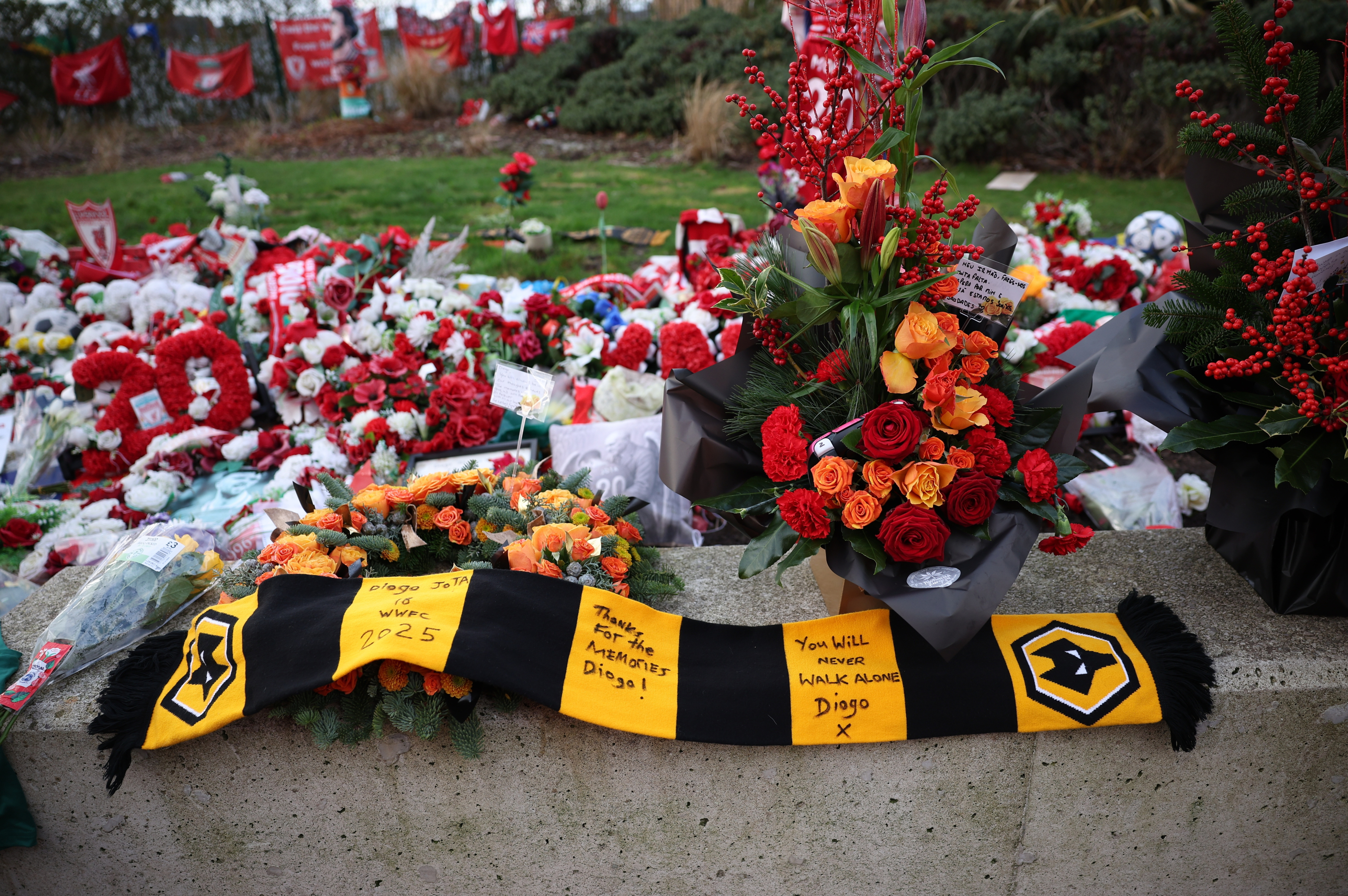 Scarves and flowers in memory of Diogo Jota on the outskirts of Anfield.