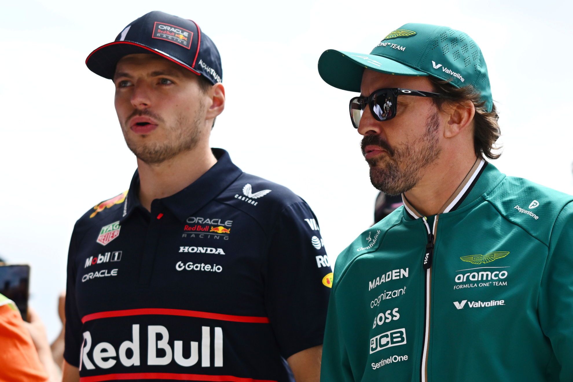 Max Verstappen camina junto a Fernando Alonso.