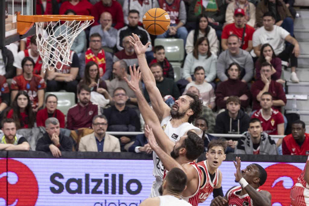 Sergio Llull lanza a canasta ante la presión de Emanuel Cate.