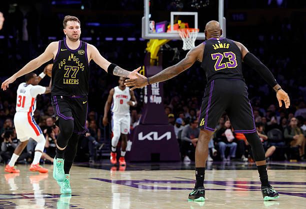 Luka Doncic y LeBron James chocan la mano tras una acción.