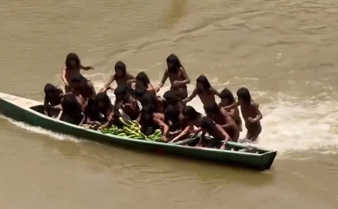 Indígenas cogiendo alimentos.