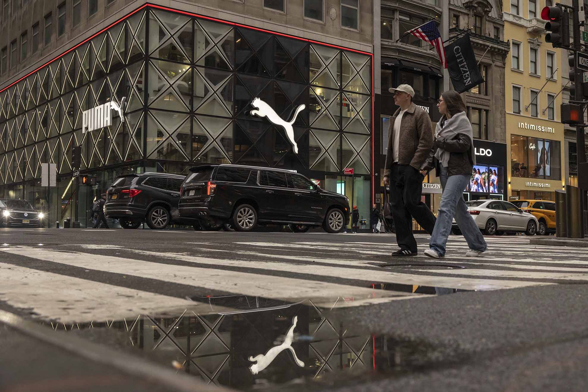 People walk past the Puma store on the 5th Avenue, Monday, April 7, 2025, in New York. (AP Photo/Yuki Iwamura)