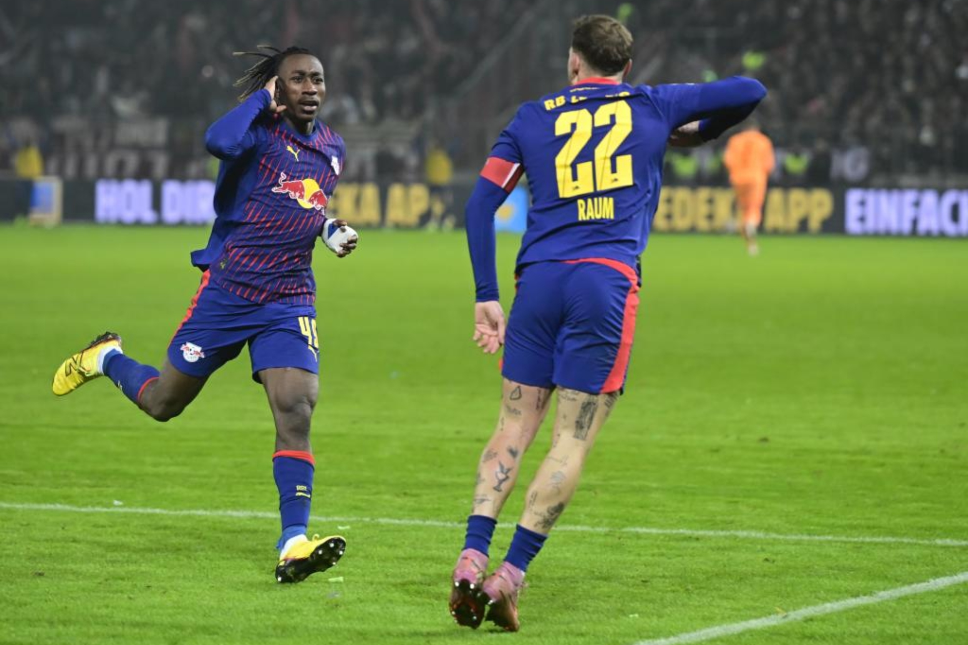 Yan Diomande celebra su gol con David Raum.