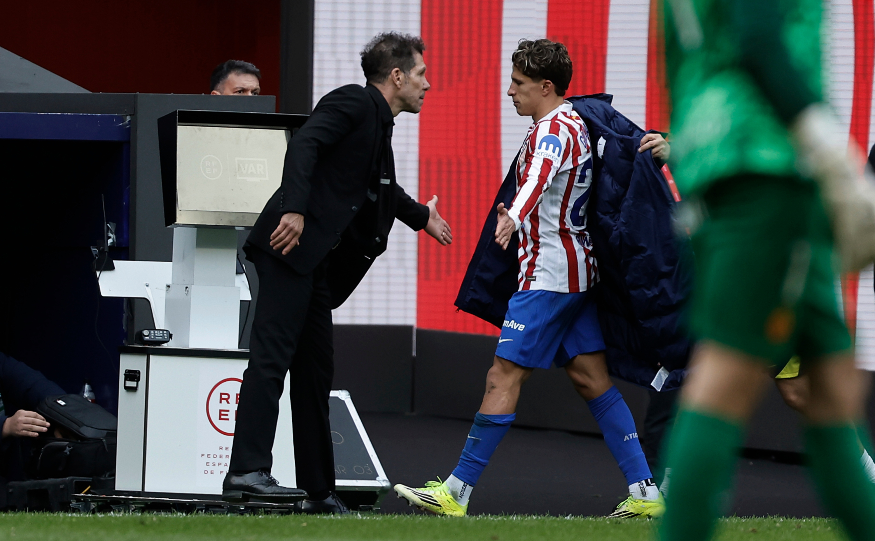 Giuliano saluda al Cholo durante un partido.