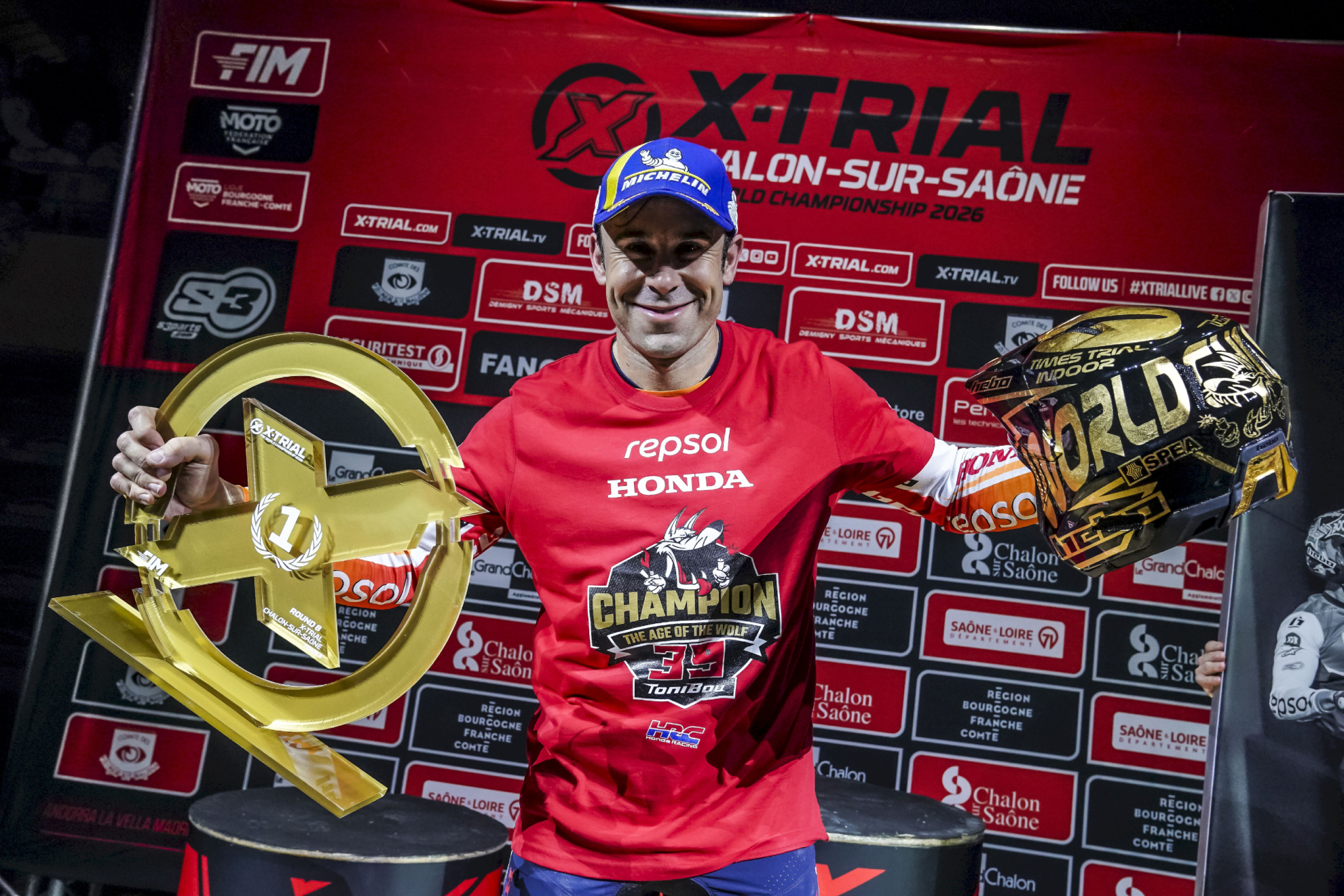 Toni Bou posando con el trofeo de ganador y el casco de oro por su 39º título mundial.