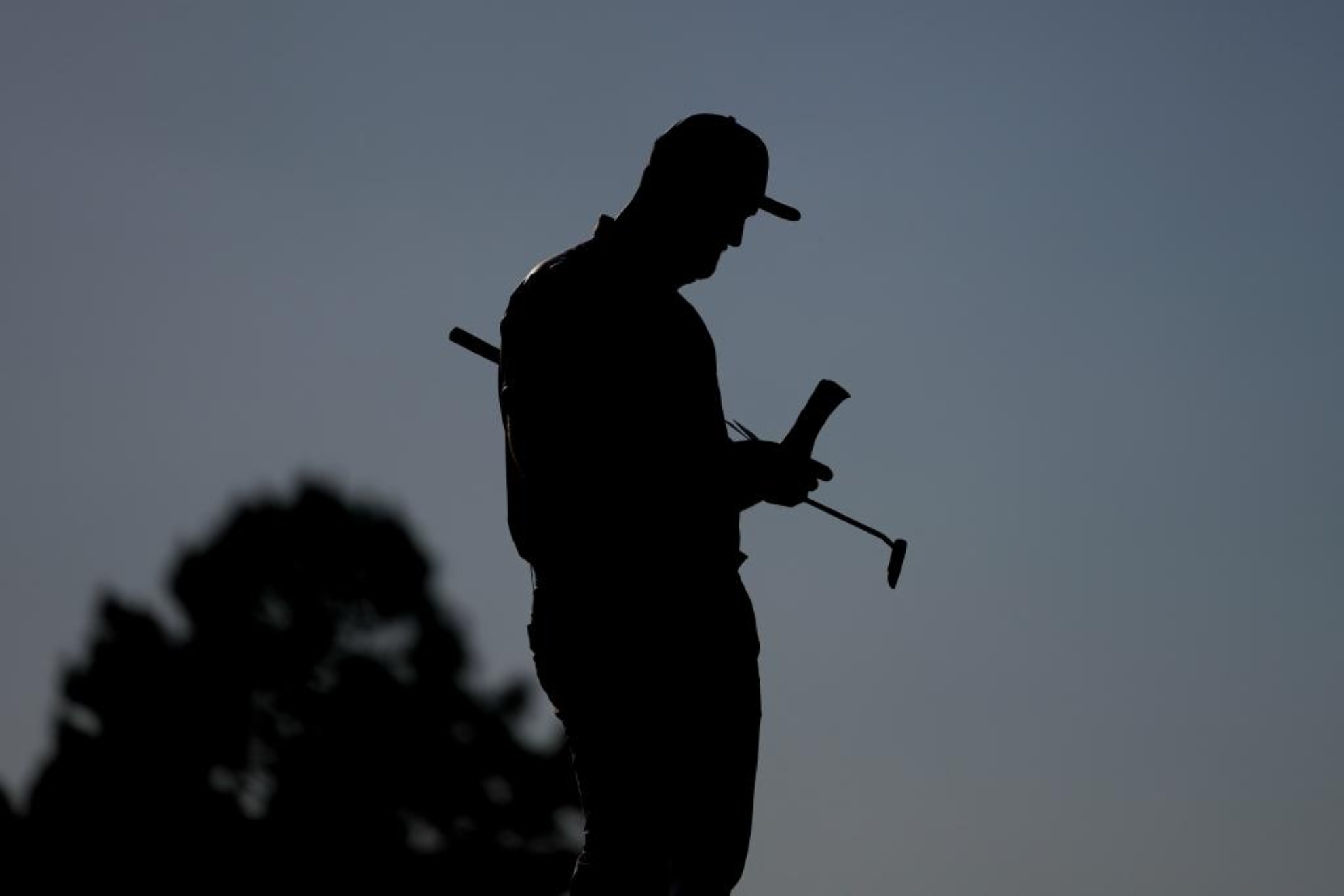 Jon Rahm (31) lee su libro de notas en el hoyo 17