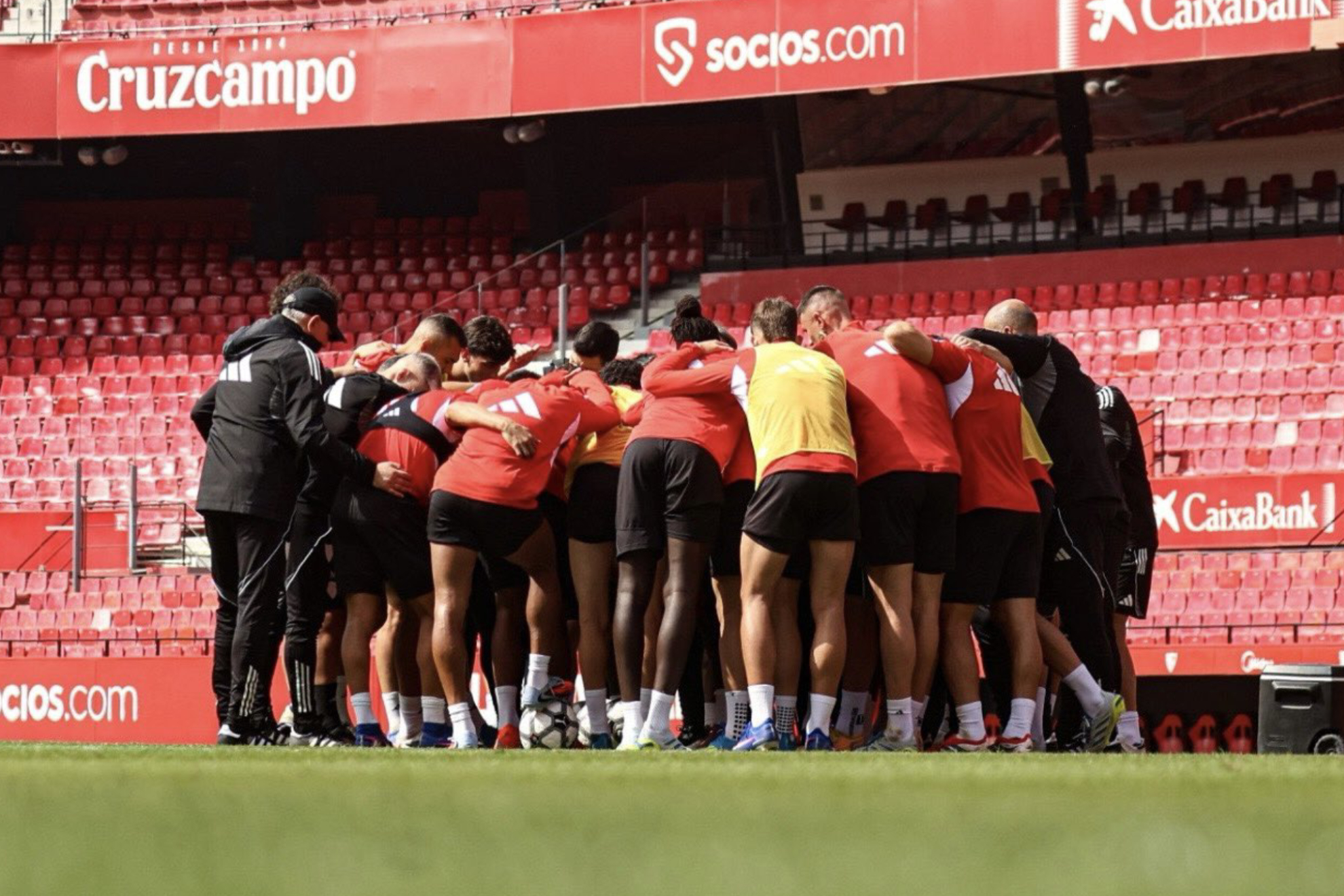 Los jugadores del Sevilla hacen piña tras la sesión de entrenamiento en el estadio.