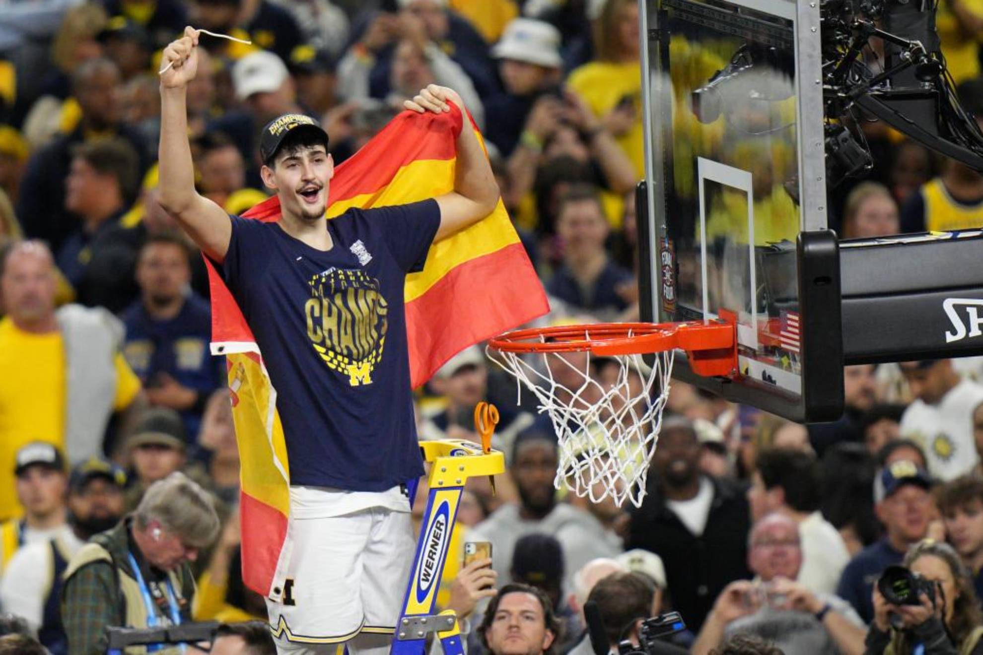 Aday Mara corta la red de la canasta tras ganar la NCAA con la Universidad de Michigan.