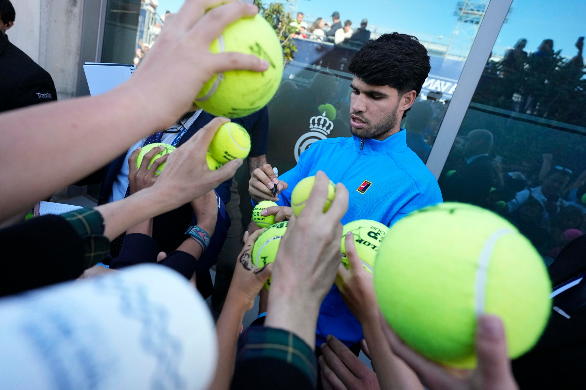 Alcaraz, firmando pelotas de tenis.
